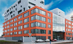 Moderní budova SILO v Brništi s velkými okny a červenou fasádou.