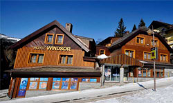 Moderní hotel SILO v Brništi s dřevěnou architekturou a sněhem.