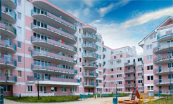 Moderní bytový dům SILO v Brništi s balkony a zelení.