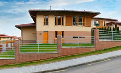 Moderní dům v Brništi s oploceným pozemkem a zelení.